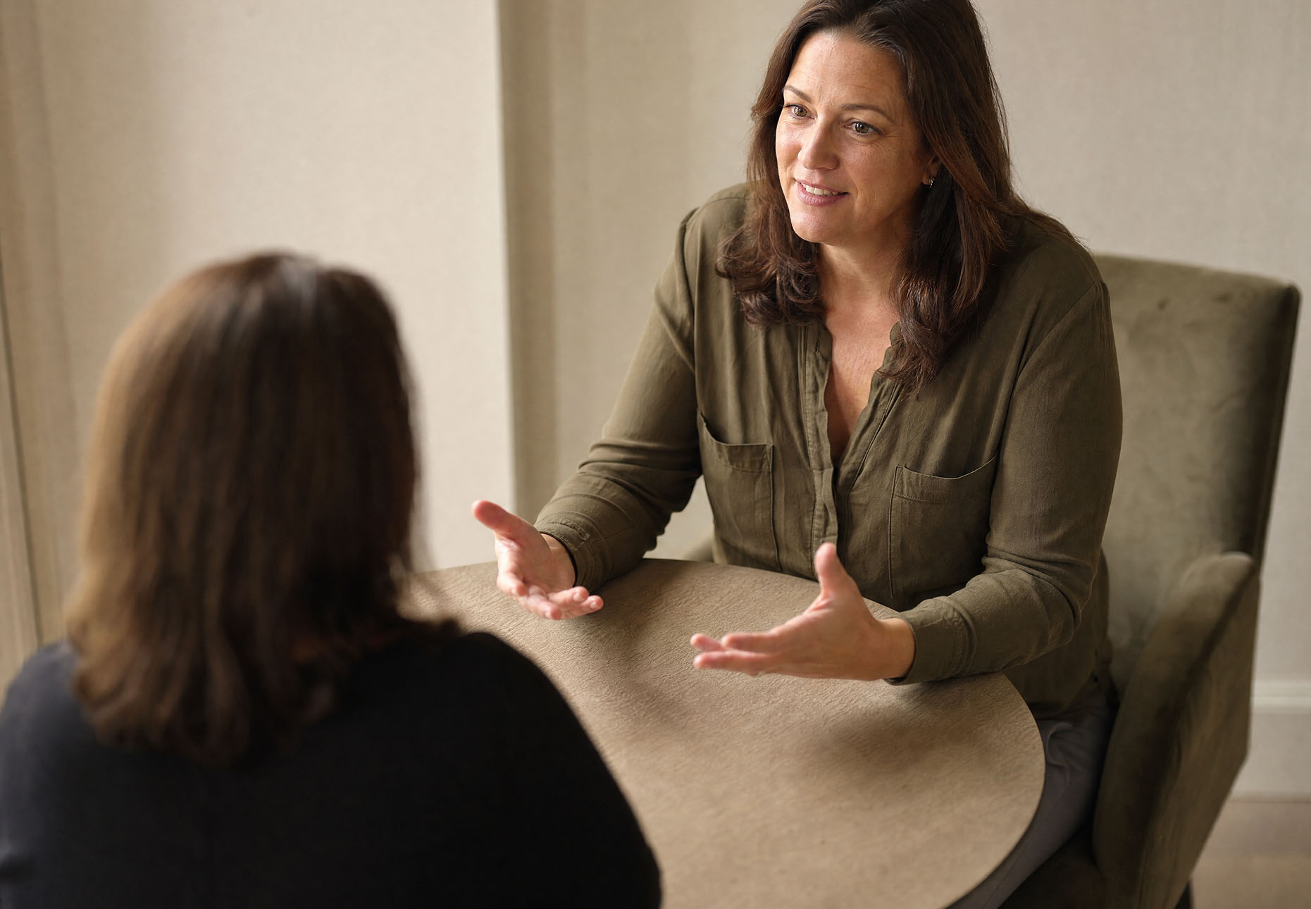 Two women talking in a warmly lit room